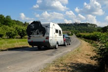 a caravan being towed along a country road